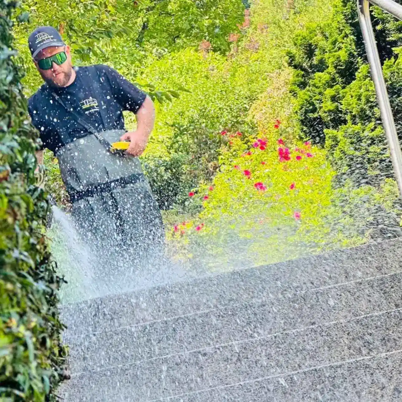 Gartenarbeiter reinigt Boden mit Hochdruckreiniger