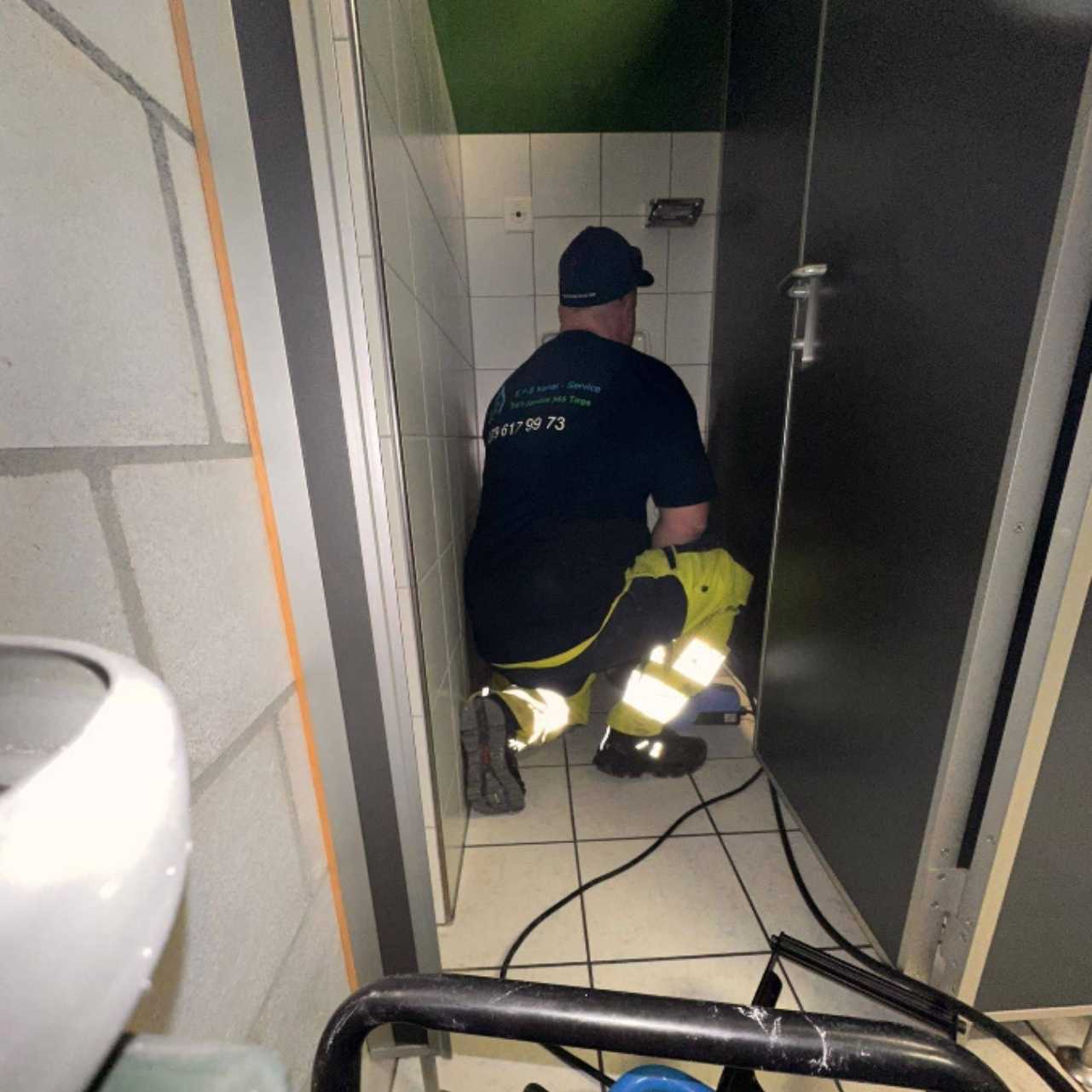Handwerker führt Rohrreinigung und Sanitärarbeiten im Rohbau durch